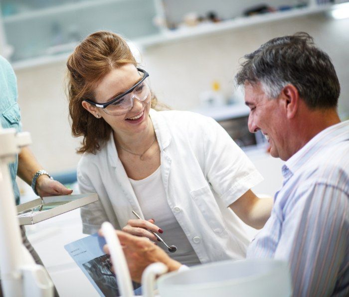 Two dental team members laughing together in dental office