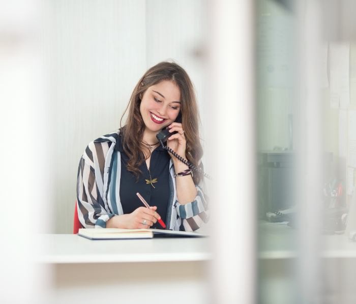 Smiling team member at dental office talking on phone