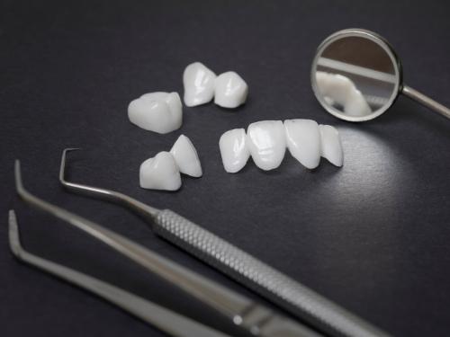 Several dental crowns on table with dental instruments