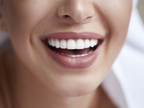 Close up of person smiling with straight white teeth