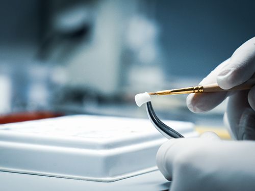 A lab worker making dental crowns