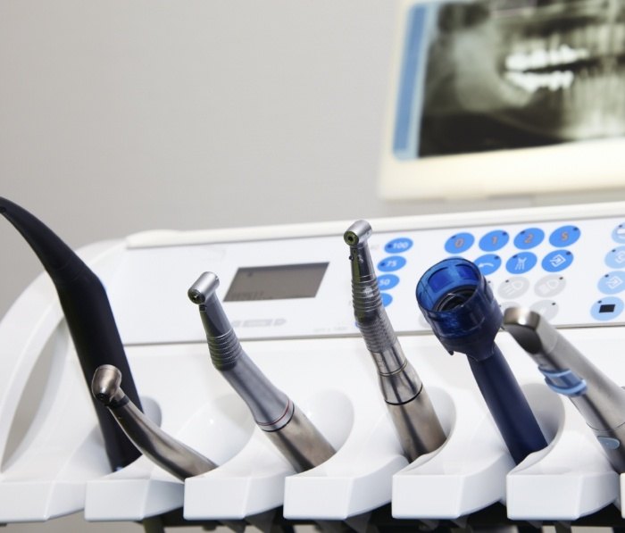 Table holding several advanced dental instruments in dental treatment room