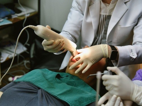 Dentist using cavity detection scanner while examining a patient