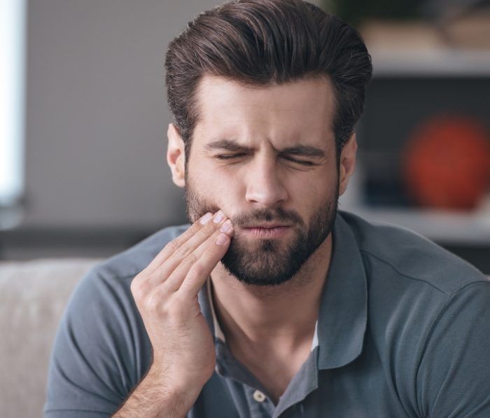 Man holding his cheek in pain