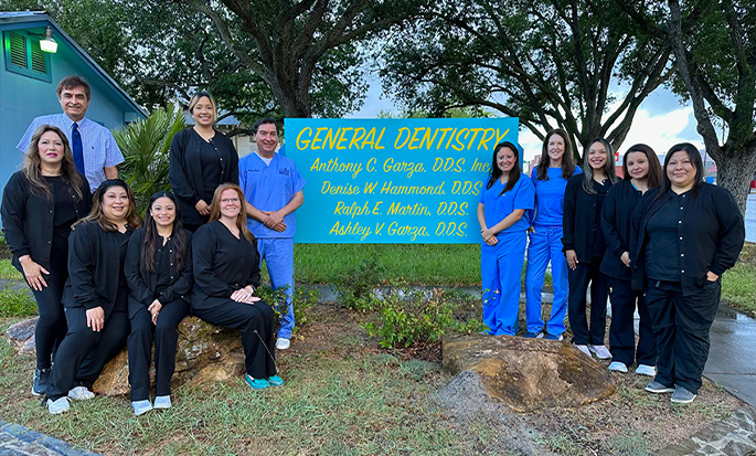 Dental team standing outside next to sign for Anthony C Garza D D S