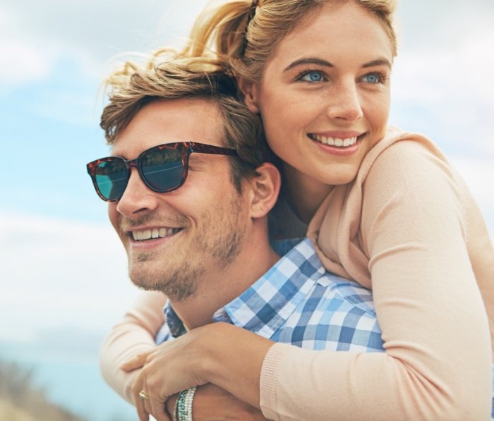 Smiling man and woman holding each other outdoors