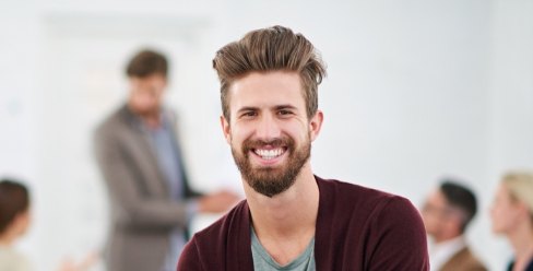 Young man in red cardigan grinning
