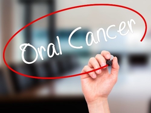 Hand using a marker to circle the words oral cancer